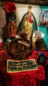 Altar at the Voodoo Museum, featuring 4 depictions of Mother Mary and a dolalr bill that says,"You are better than the worst thing you have done."