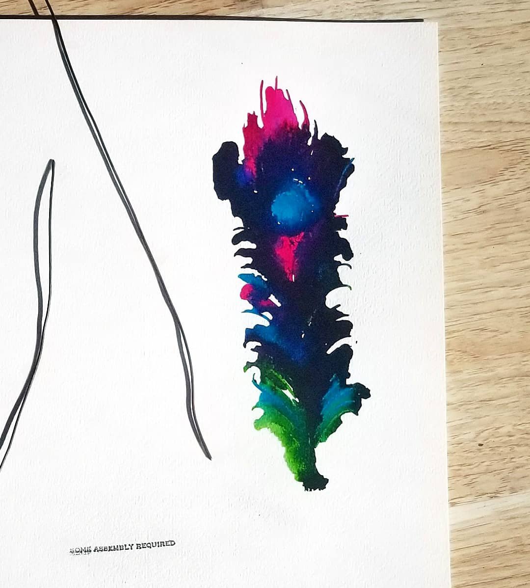 Collage of multicolored feather in inks, a stamp that says 